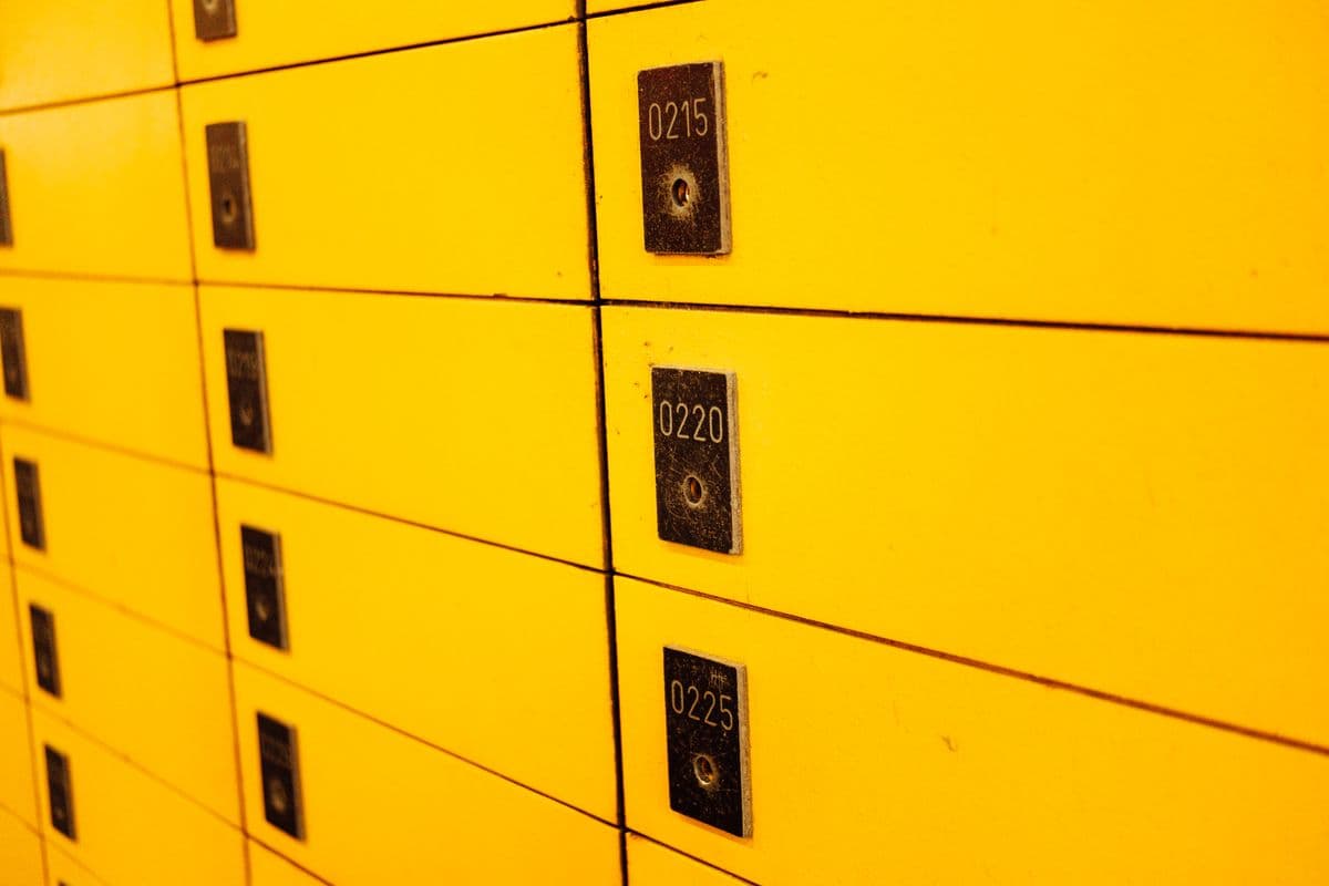 Rows of yellow safe deposit boxes with dark metal plates numbered 0215, 0220 and 0225, each with its own keyhole. Backup codes work the same way: each one opens the door exactly once, and then it is spent.
